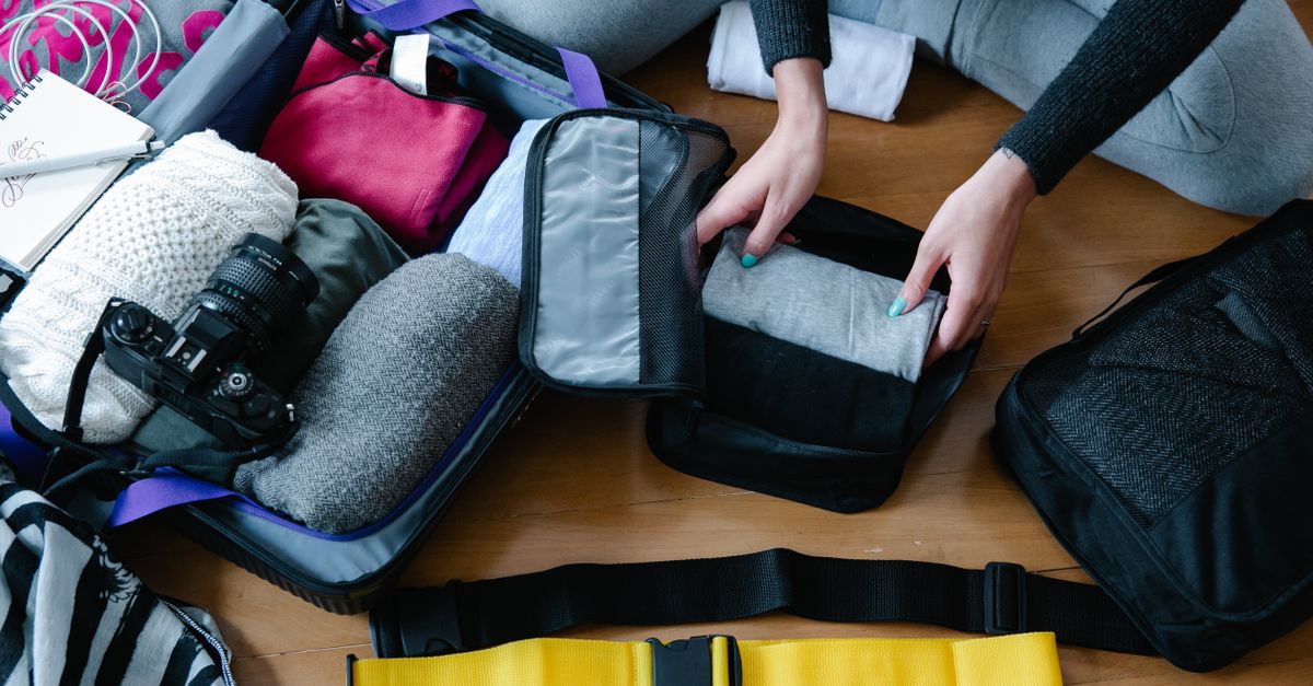 A lightweight rain jacket and a dry bag laid out for packing.